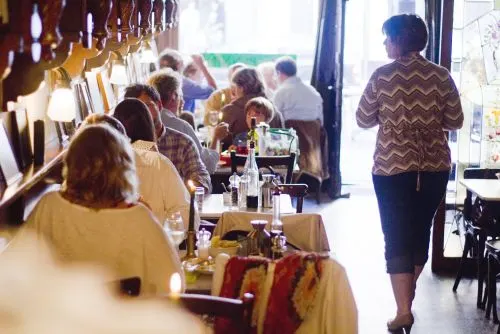 Gasten aan tafel bij het raam