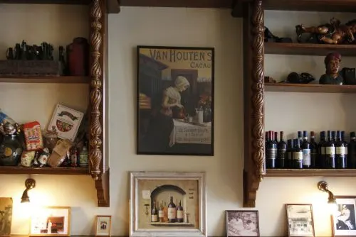 Wandkasten met wijn, lijsten en Italiaanse spulletjes