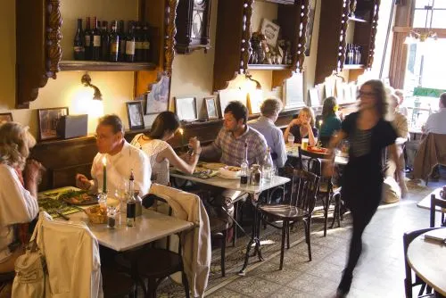 Gasten aan tafel in het volle restaurant